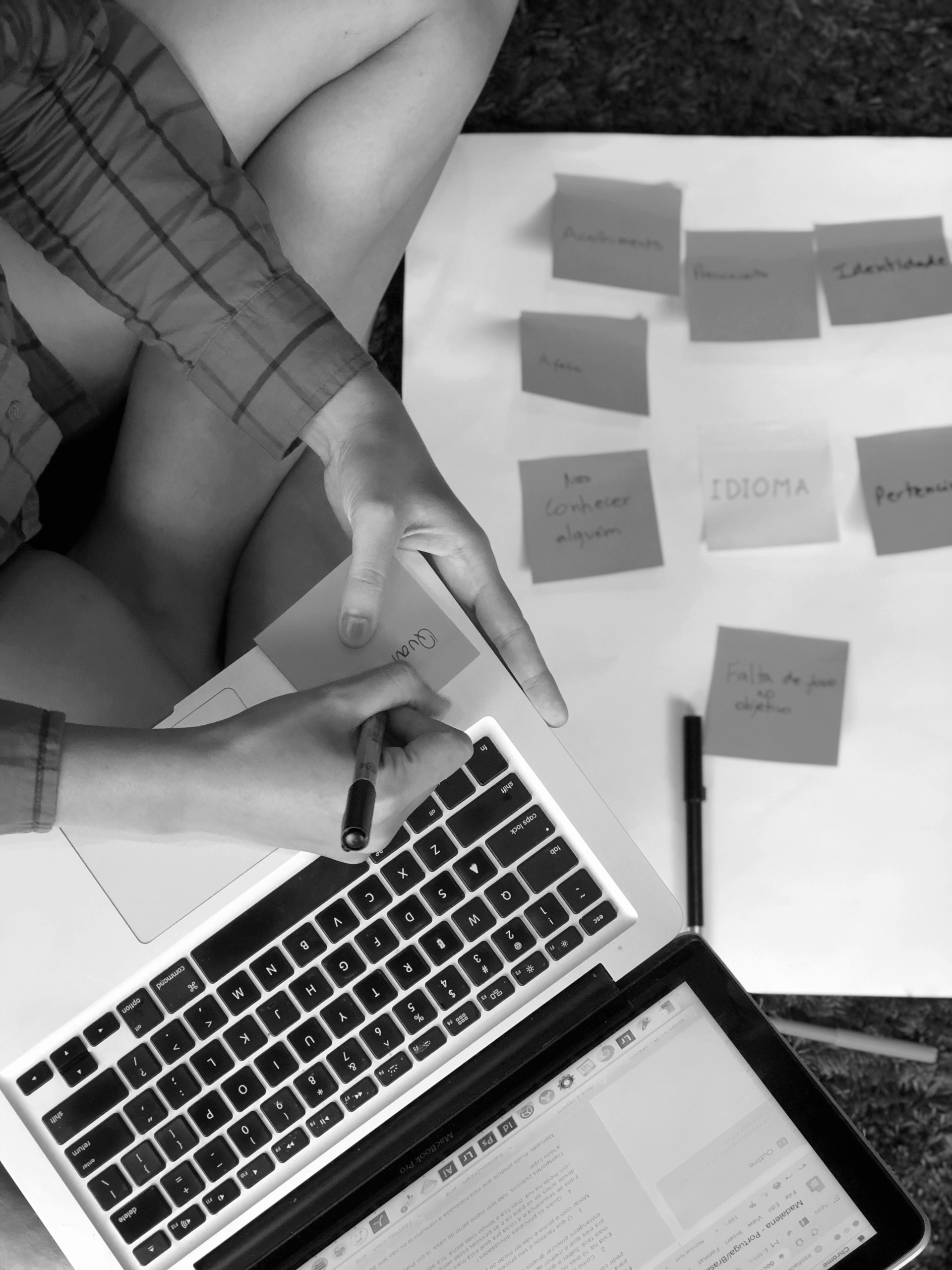 UX research session with a laptop and handwritten notes, showing user insights categorized with post-it notes.